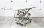 Medical, Morgue, TABLE W/FLAT SURFACE FOR BODY TRANSPORT OR AUTOPSY, LARGE WHEEL FOR HYDRAULIC LIFT OR TO RAISE/LOWER, SCISSOR LIFT BASE, ROLLING, STAINLESS STEEL, SILVER